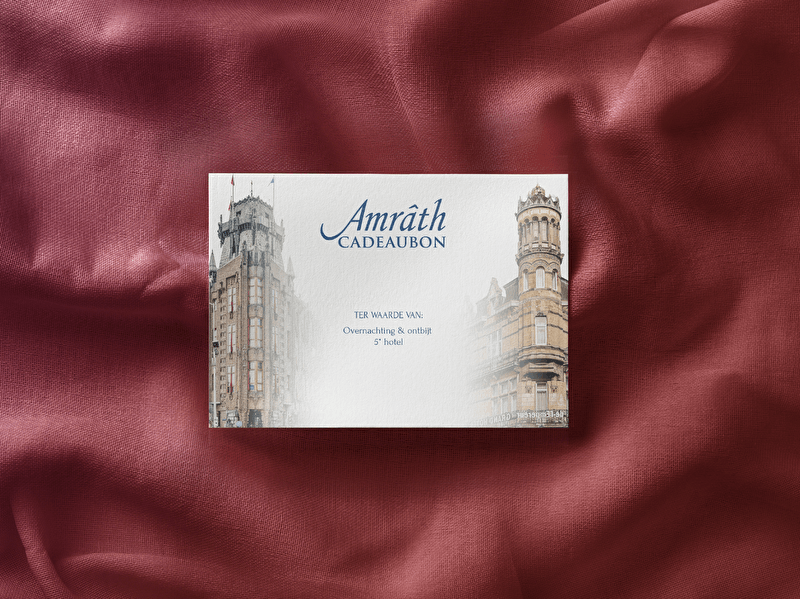 An Amrâth gift card displayed on a luxurious red satin background. The card features two historic buildings and states: "Amrâth Gift Card, value for: Overnight stay & breakfast, 4* hotel.