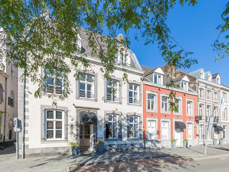 Voorzijde van Amrâth Hotel Bigarré in Maastricht, historisch gebouw met witte en rode gevels in een rij herenhuizen.